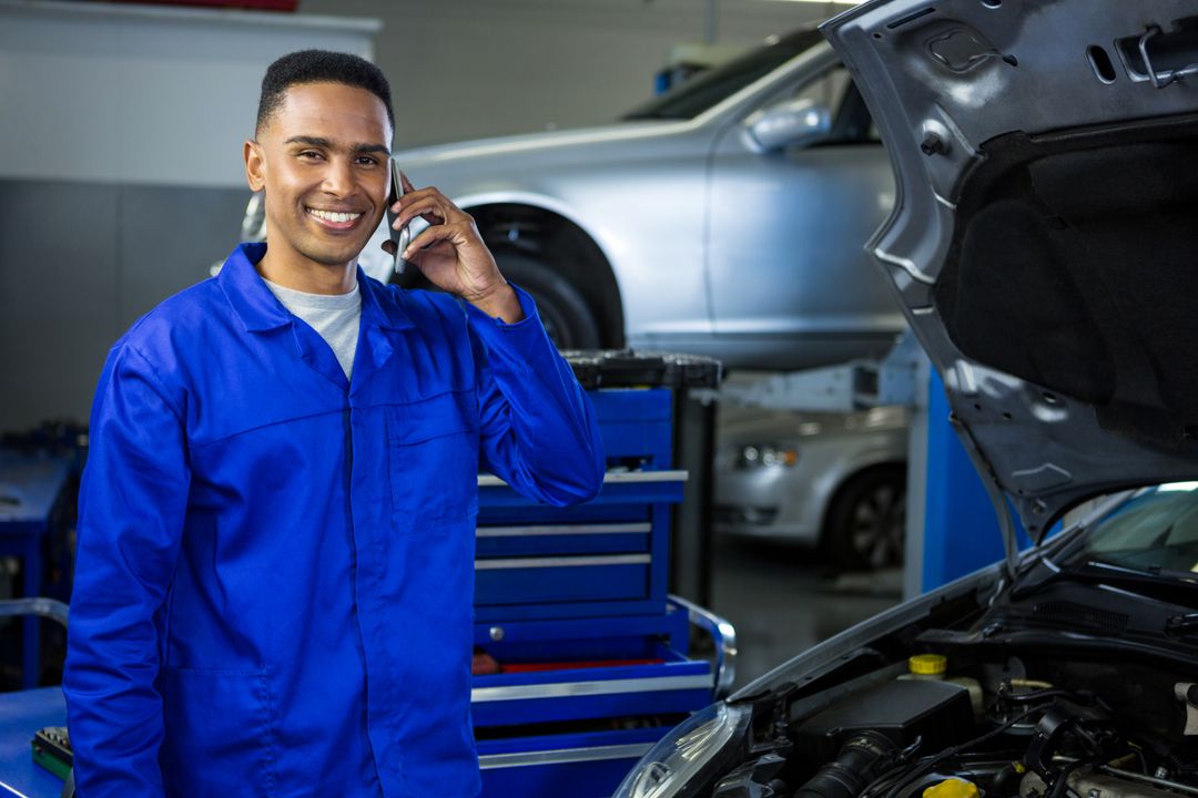 Auto mechanic taking a customer call in a repair shop